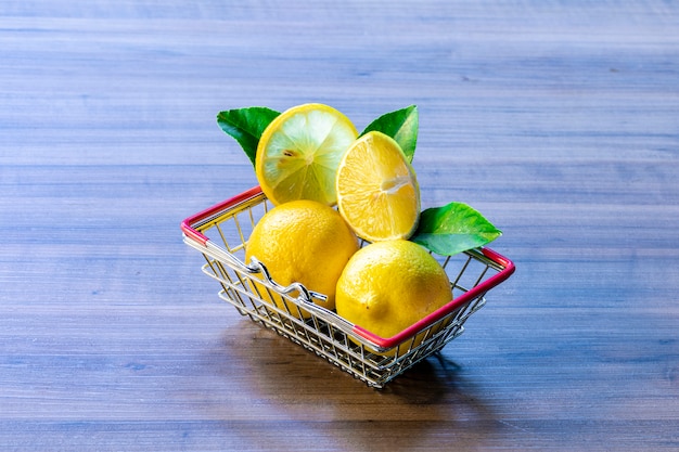 Supermarket basket carrying green leaf and lemon