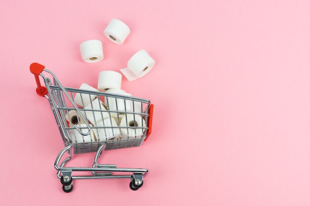 Supermarket cart with toilet paper thrown on the floor. COVID-19 concept. Copy space.