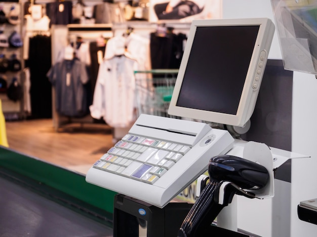 Supermarket cash desk checkout counter payment terminal with blank computer monitor screen