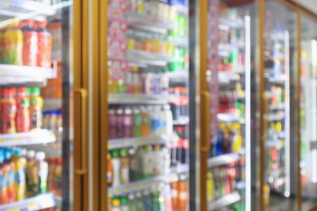 Supermarket convenience store refrigerators with soft drink bottles on shelves blur background