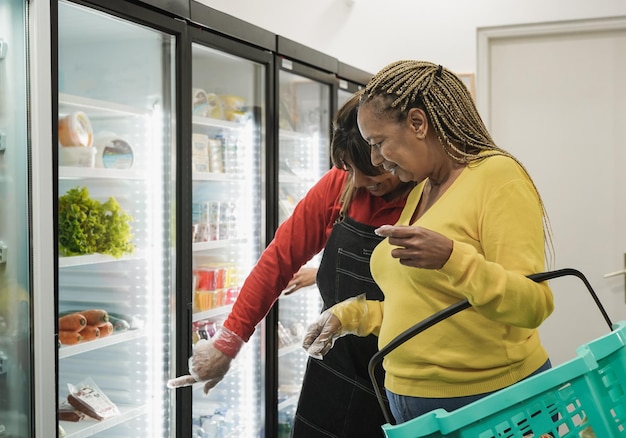 Supermarket employee helping a customer to choose