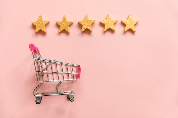 Supermarket grocery push cart gold stars rating isolated on pink pastel background