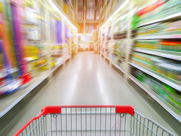 Supermarktdoorgang met leeg rood boodschappenwagentje