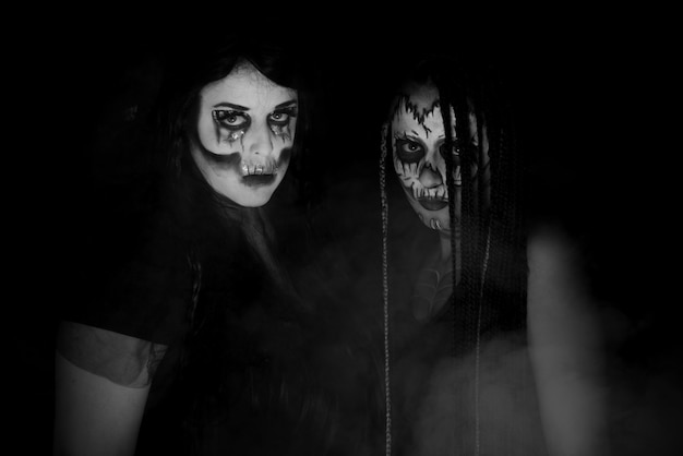 Photo supernatural entities, portrait of two supernatural entities, artistic makeup, black background, low key portrait, selective focus.