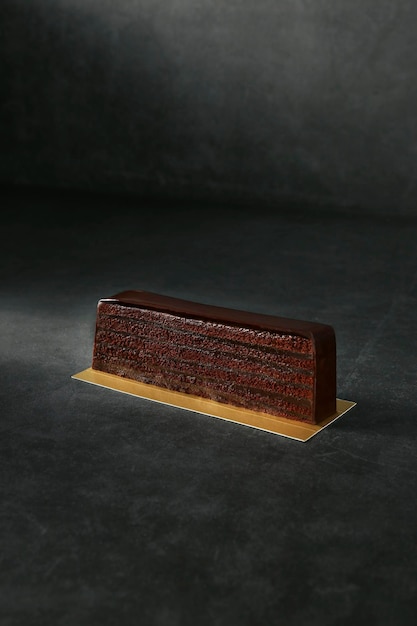 Суперсложенный шоколадный торт, изолированный на темном фоне, вид сверху на выпечку десерта