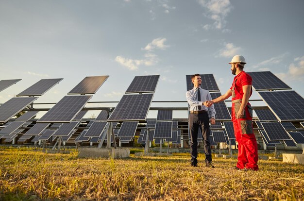 Фото Супервайзер и инженер пожимают друг другу руки в области солнечной энергетики