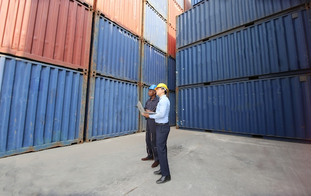 supervisor checking and control loading Containers box from Cargo at harbor.