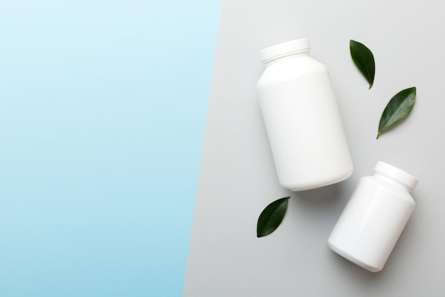 Supplement pillen met medicijnfles gezondheidszorg en medisch bovenaanzicht Vitamine tabletten Bovenaanzicht mockup fles voor pillen en vitamines met groene bladeren natuurlijke organische bio supplement kopieerruimte