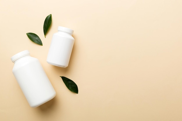 Supplement pillen met medicijnfles gezondheidszorg en medisch bovenaanzicht Vitamine tabletten Bovenaanzicht mockup fles voor pillen en vitamines met groene bladeren natuurlijke organische bio supplement kopieerruimte