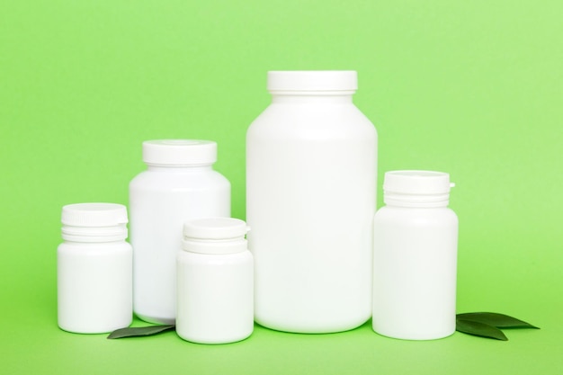 Supplement pillen met medicijnfles gezondheidszorg en medisch bovenaanzicht Vitamine tabletten Bovenaanzicht mockup fles voor pillen en vitamines met groene bladeren natuurlijke organische bio supplement kopieerruimte