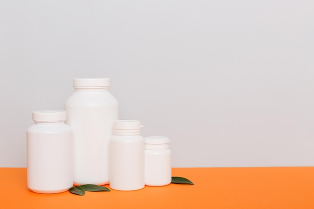 Supplement pillen met medicijnfles gezondheidszorg en medisch bovenaanzicht Vitamine tabletten Bovenaanzicht mockup fles voor pillen en vitamines met groene bladeren natuurlijke organische bio supplement kopieerruimte