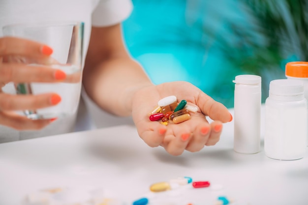 Supplementation Woman holding a myriad of vitamin and mineral supplements in her hand