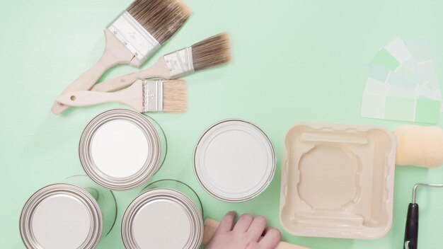 Supplies to start house painting project. metal paint cans,\
paint brushes, and paint swatches.