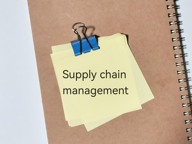 supply chain management words with sticky notes note book and a pen