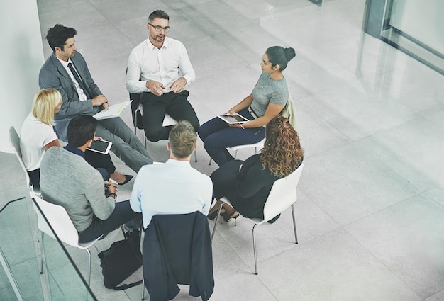 현대적인 사무실에 함께 앉아 있는 비즈니스 회의에서 동료들의 보살핌과 화합을 지원하는 창의적인 팀 위의 브레인스토밍 계획 및 아이디어나 목표 공유