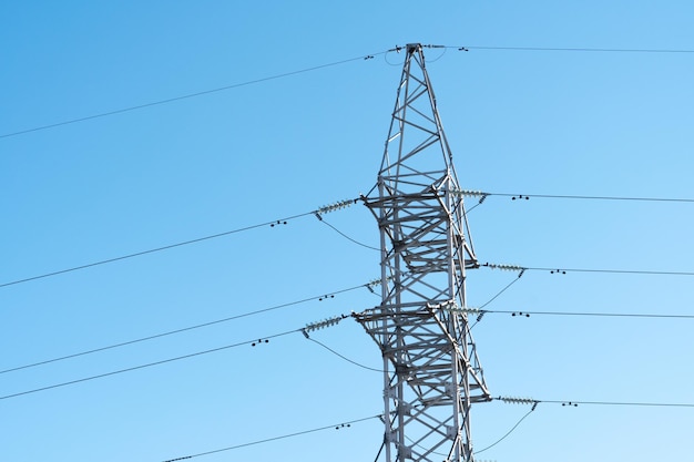 Support of an overhead power line transmission of electricity\
from a powerful power plant to the city poles with wires on the\
background of a beautiful sky