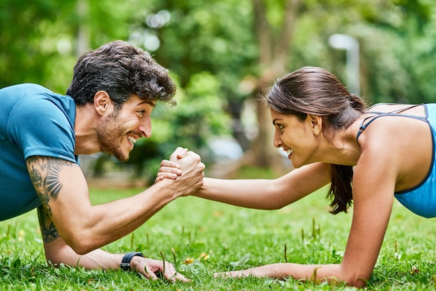 より健康的なライフスタイルに向けてお互いをサポート屋外で一緒に運動するスポーティな若いカップルのショット