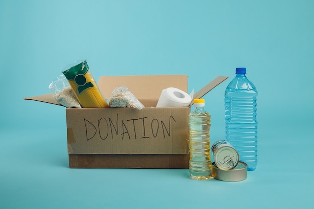 Supportive housing or food donation for poor. Donation box on a blue background.