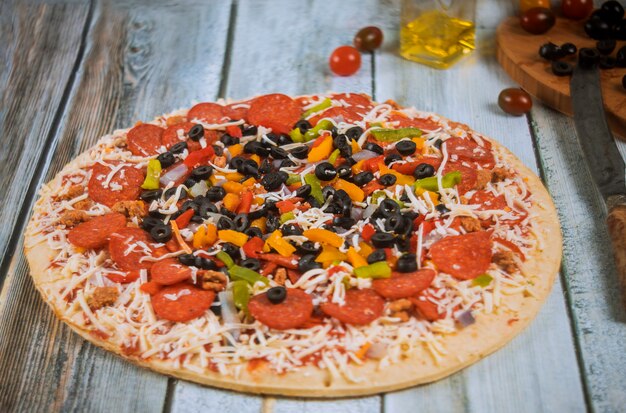 Supreme pizza met olijven, uien, worst en paprika