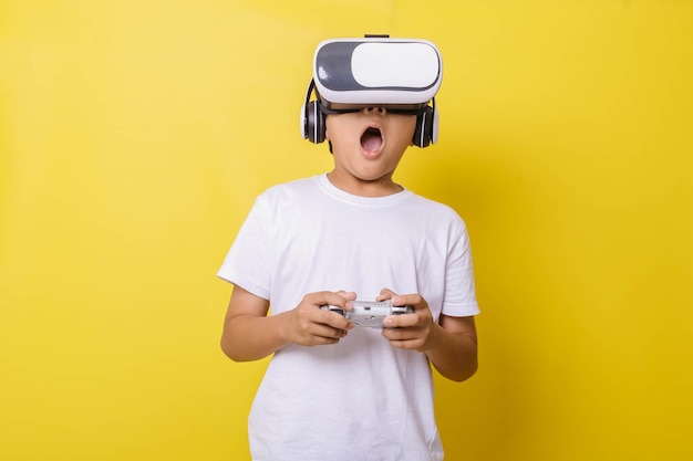 Suprised little boy enjoying playing in virtual reality game\
isolated on yellow background