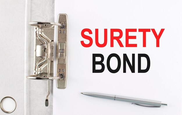 Текст SURETY BOND на бумажной папке с ручкой Бизнес-концепция