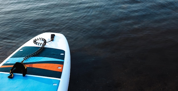 사진 푸른 깨끗한 물 표면 배경의 서핑 보드 일몰 조명 근접 촬영에서 sup 탑승 장비 야외 수상 스포츠 바다 또는 바다에서 수영을 위한 장비 임대 여름 시간