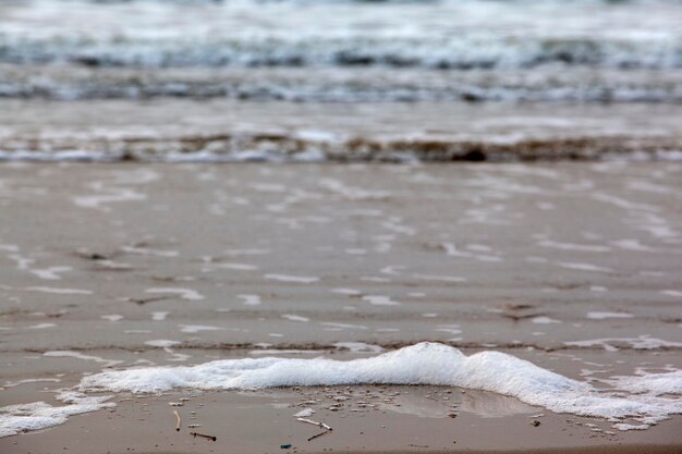 Surf on sandy seashore