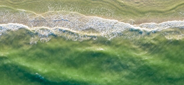 Surf waves on the seashore top view summer background