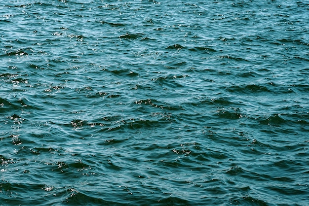 Surface of deep blue ocean water with small waves in closeup high details