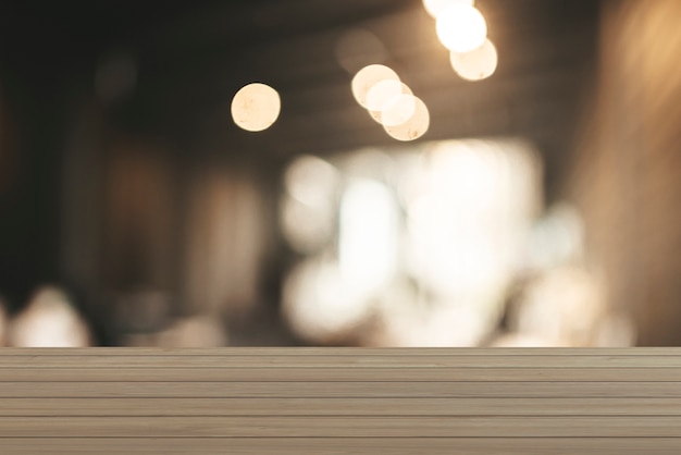 The surface on the empty wooden table and the blur background of the kitchen in the cafe.