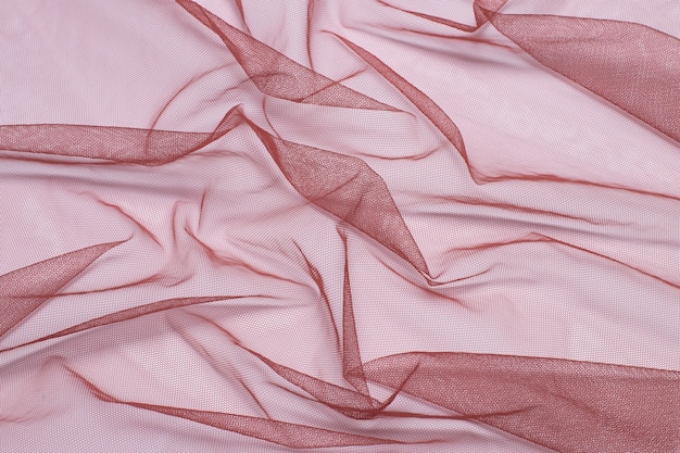 surface from a crumpled, compressed red cloth tulle mesh