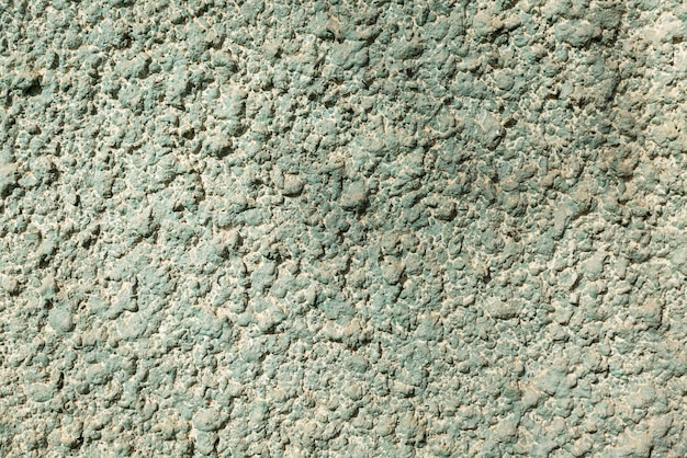 Foto superficie di un muro di cemento grigio-verde con trucioli. costruzione e riparazione. avvicinamento. sfondo. spazio per il testo.