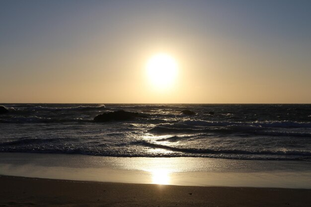 Surface level of calm beach at sunset