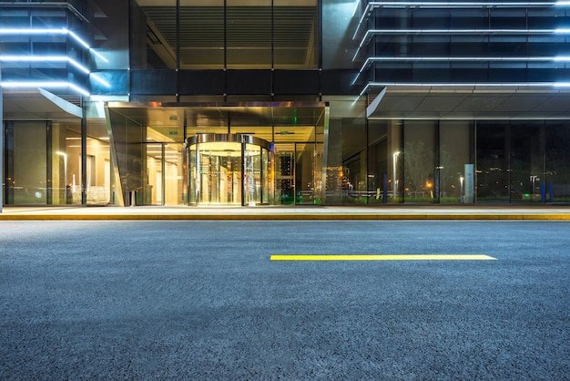 Photo surface level of empty road against buildings at night