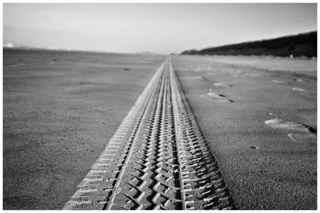 Photo surface level of railroad tracks on beach against sky