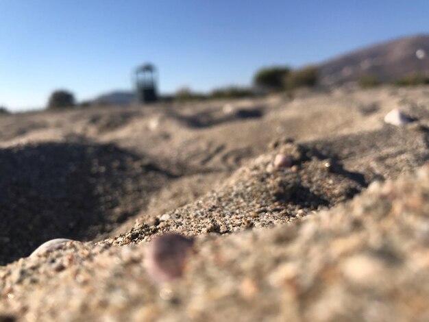 Surface level of sand on beach against clear sky