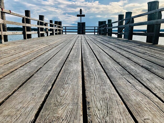 Photo surface level view of pier on footbridge against sky