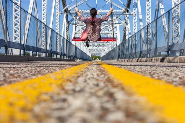 Surface level of woman swinging on bridge