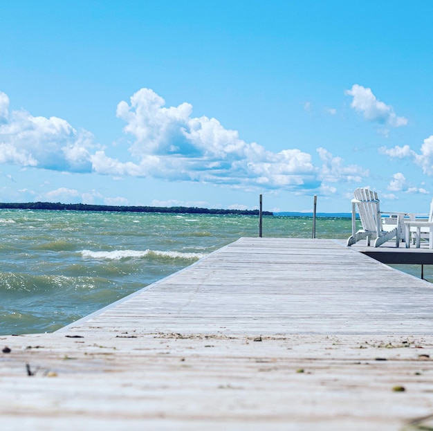 Surface level of wooden pier at beach against sky