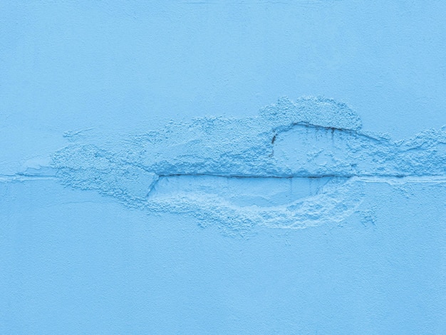 Поверхность, полученная в результате цементной штукатурки, выбитой из стены, выглядит шероховатой