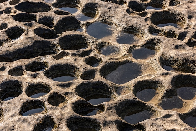 Surface of the rock with round holes