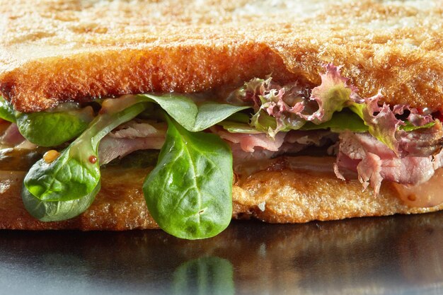 поверхность бутербродов с ветчиной, салатом, огурцом и гренками на гриле