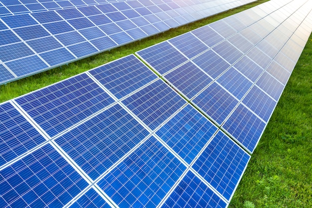 Superficie del sistema fotovoltaico solare dei pannelli fotovoltaici che produce energia pulita rinnovabile su erba verde.