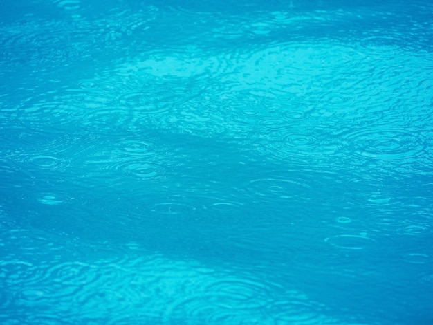 The surface of swimming pool and water expanding ripple effect background.