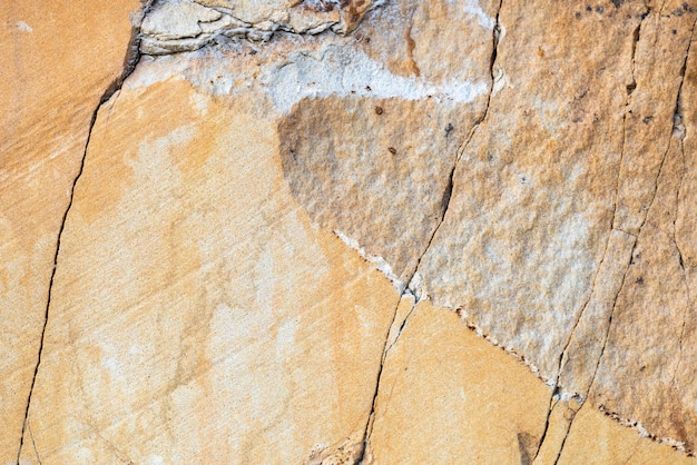 Surface texture of sandstone stone with cracks for background