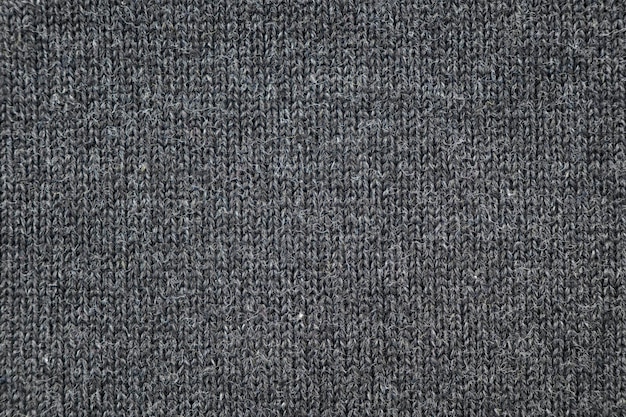 Surface of warm winter knitted gray sweater as background or texture top view