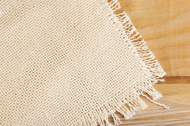 surface of white coarse linen cloth on a wooden Board