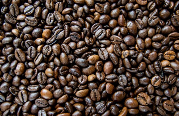 Surface with roasted coffee beans background Top view