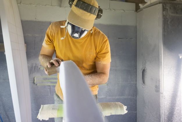 Surfboard shaper file down the rough edges in workshop