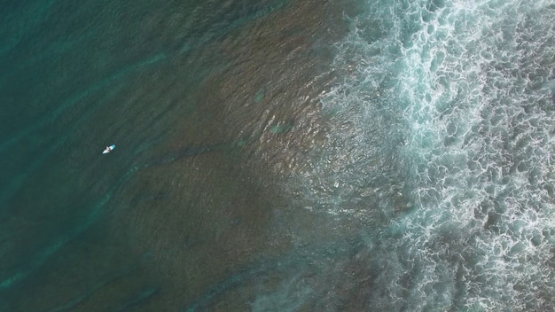 Surfen vanuit de lucht, luchtfoto bovenaanzicht van strand met oceaan golven op Bali